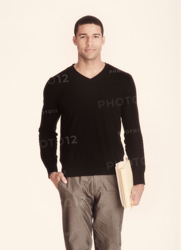 Studio portrait of man holding folders.