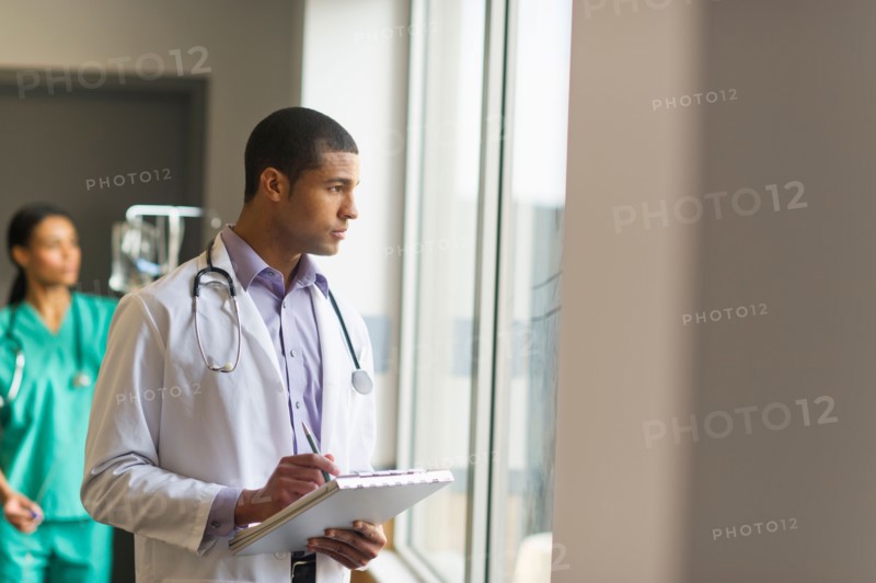 Doctor looking through window.