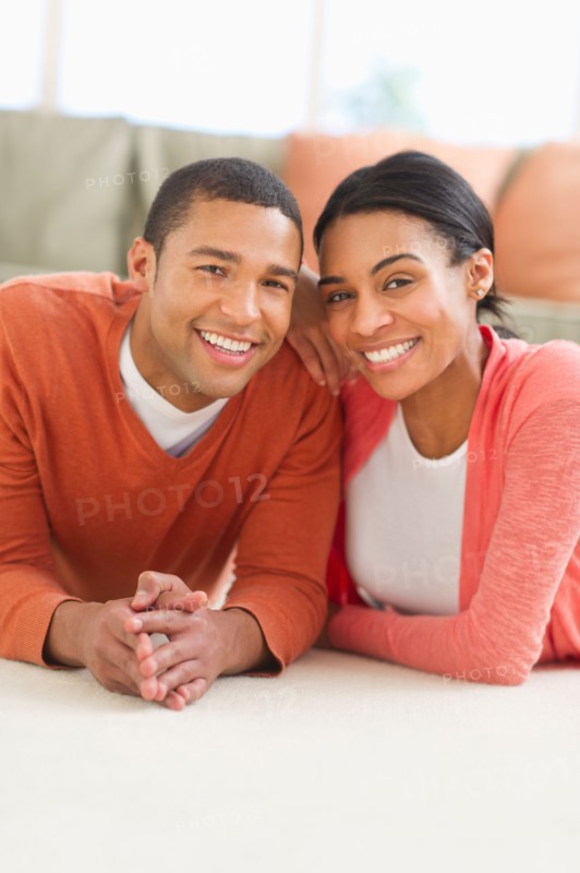 Portrait of couple lying on floor.
