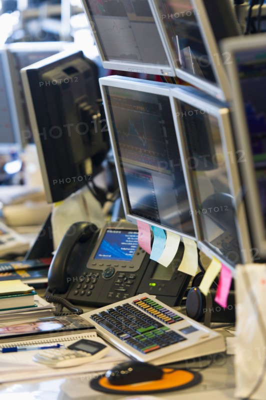 Trading desk with computers and phones.