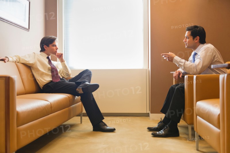 Two businessmen talking in office.
