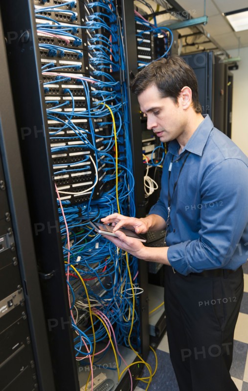 Technician inspecting network server.