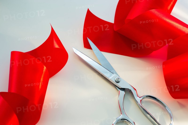 Scissors and red ribbon, studio shot.