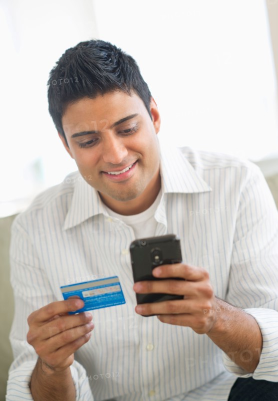 Man holding credit card and smart phone.