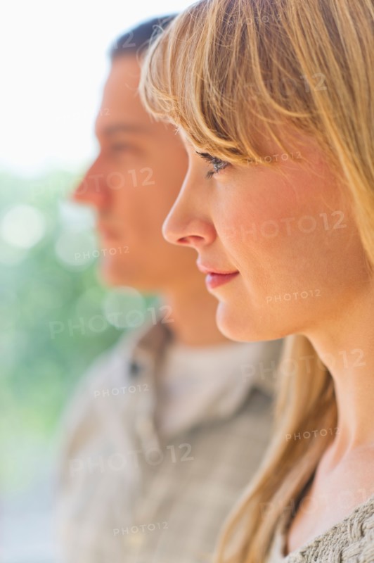 Close up woman's profile with man in background.