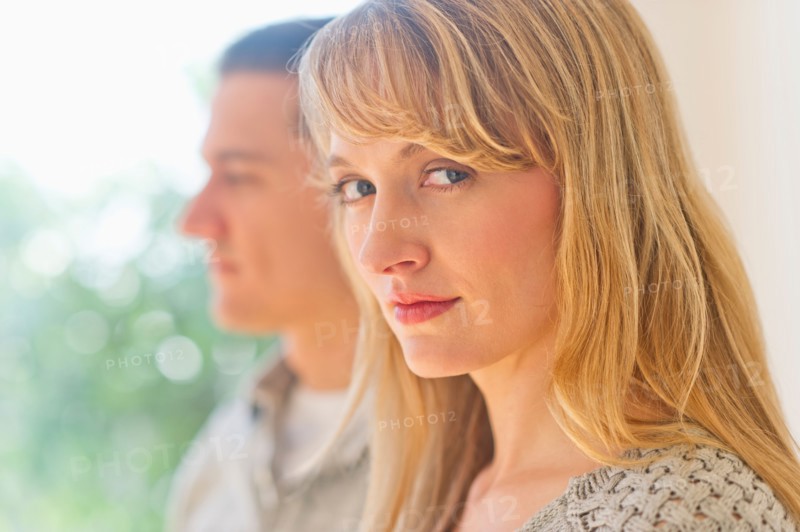 Close up woman's face with man in background.