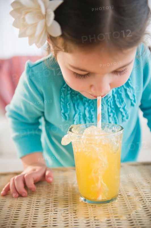 Small girl  (4-5 years) drinking juice with straw. Photo : Jamie Grill