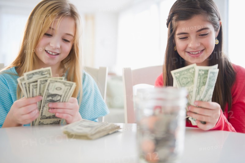Two girls counting banknotes. Photo : Jamie Grill