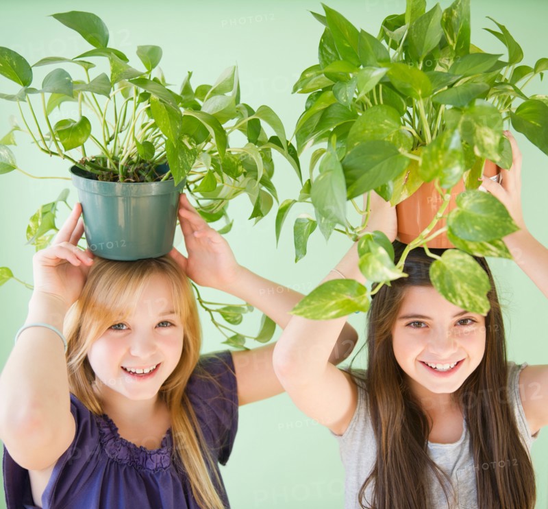 Two girls carrying potted plants on heads. Photo : Jamie Grill
