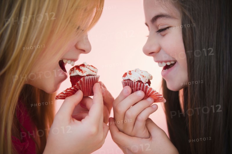 Close up of two girls eating cupcakes. Photo : Jamie Grill