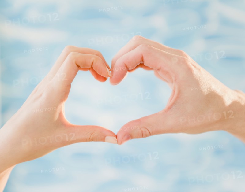 Close up of man's and woman's hands making heart shape, studio shot. Photo : Jamie Grill