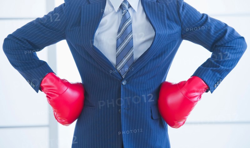 Businessman wearing red boxing gloves. Photo : Daniel Grill