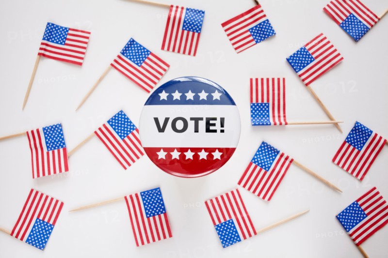 Studio shot of vote pin and small american flags. Photo : Winslow Productions