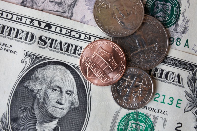 Close-up of dollar banknotes and coins. Photo : Winslow Productions