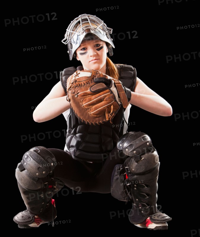 Girl (12-13) plying softball, studio shot. Photo : Mike Kemp