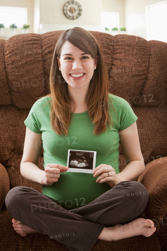 Portrait of pregnant woman showing ultrasonography scan. Photo : Mike Kemp