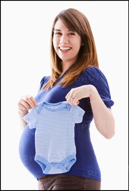 Studio Shot of woman holing baby blue onesie. Photo : Mike Kemp