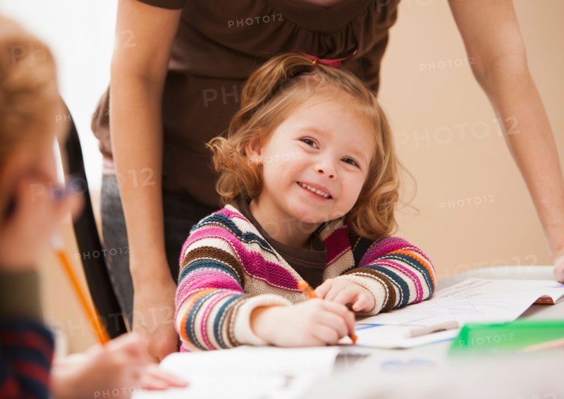 Girl (4-5) drawing in kindergarten. Photo : Mike Kemp