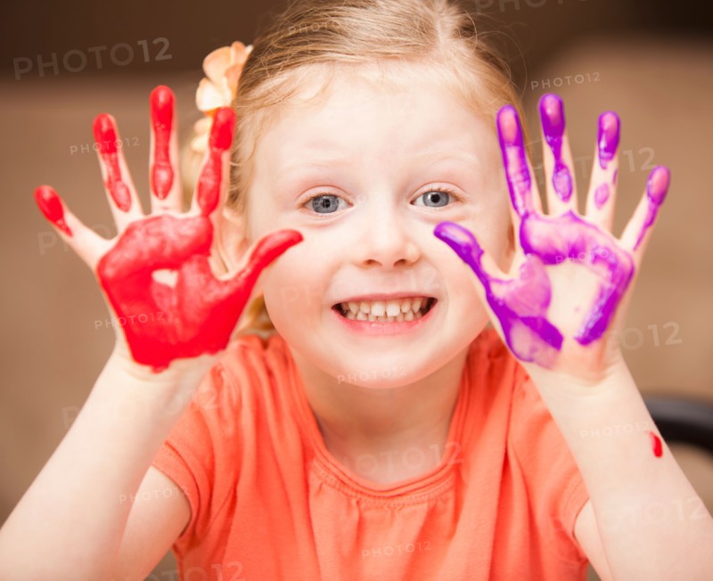 Girl (4-5) with paint covered hands. Photo : Mike Kemp