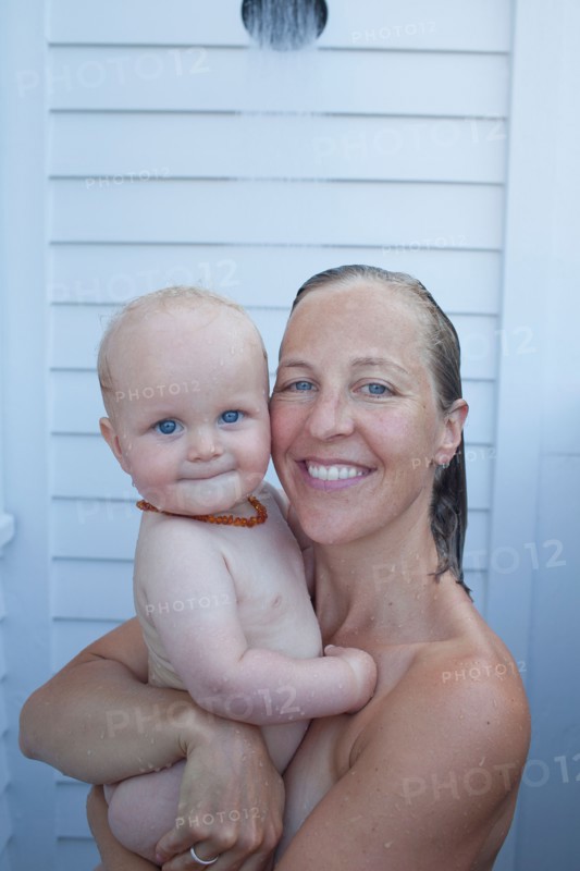 Mid adult woman having shower with her baby son (12-17 months) . Photo : Noah Clayton