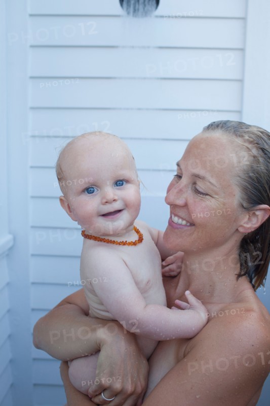 Mid adult woman having shower with her baby son (12-17 months) . Photo : Noah Clayton