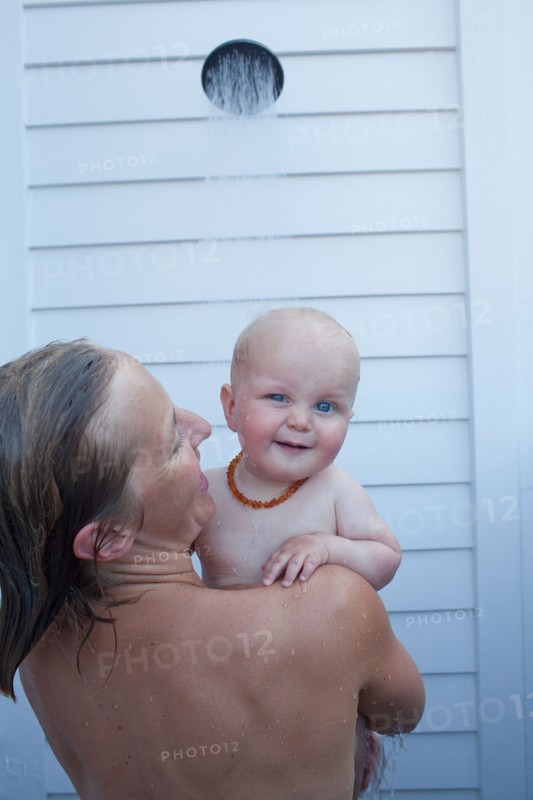 Mid adult woman having shower with her baby son (12-17 months) . Photo : Noah Clayton