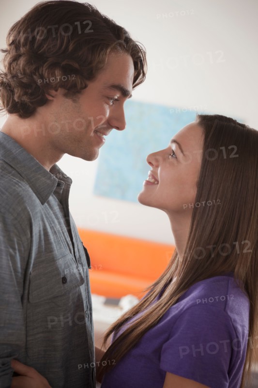 Smiling young couple looking at each other. Photo : Rob Lewine