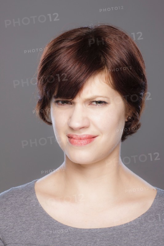 Studio shot of confused young woman. Photo : Rob Lewine