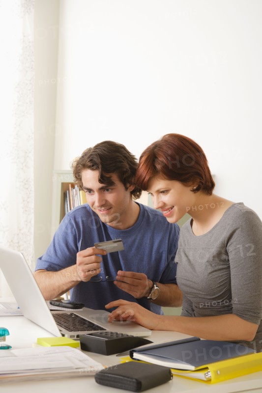 Young couple using laptop . Photo : Rob Lewine