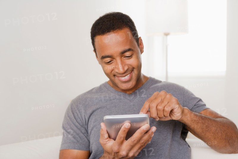 Smiling mature man using digital tablet. Photo : Rob Lewine