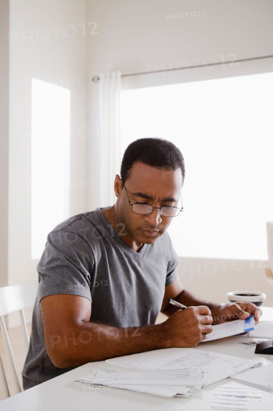 Mature man using calculator. Photo : Rob Lewine