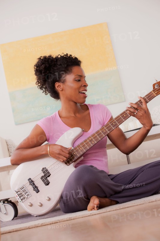 Young woman playing electric guitar. Photo : Rob Lewine