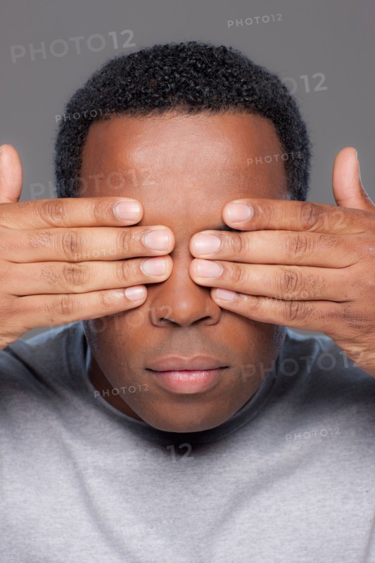 Studio shot of mid adult man covering eyes. Photo : Rob Lewine