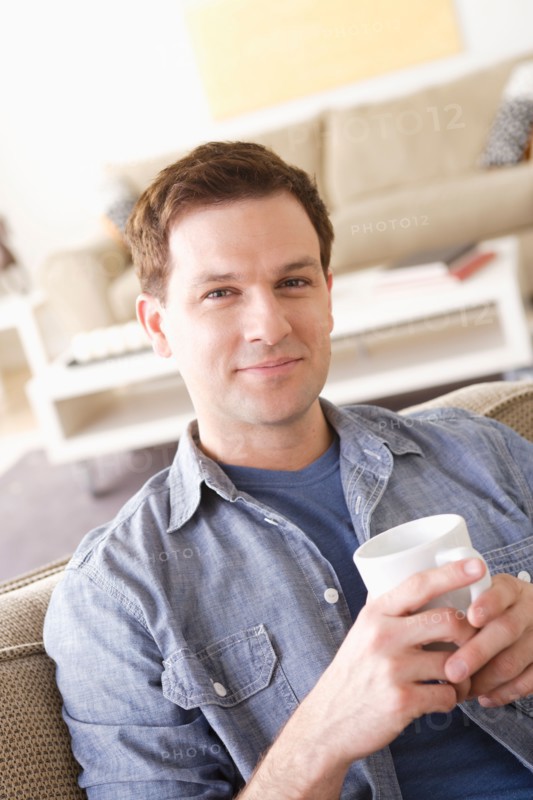 Portrait of smiling mid adult man holding mug. Photo : Rob Lewine