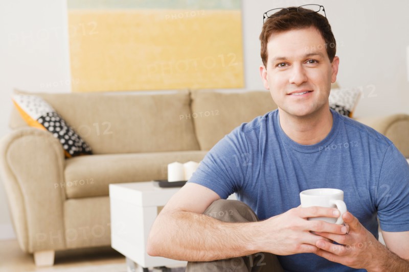 Portrait of smiling mid adult man holding mug. Photo : Rob Lewine
