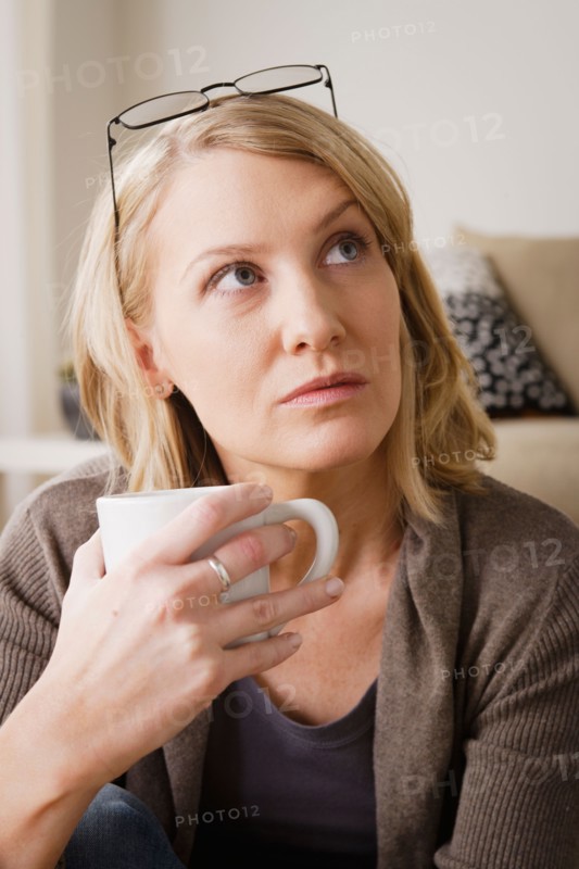 Mid adult woman drinking coffee and looking away. Photo : Rob Lewine