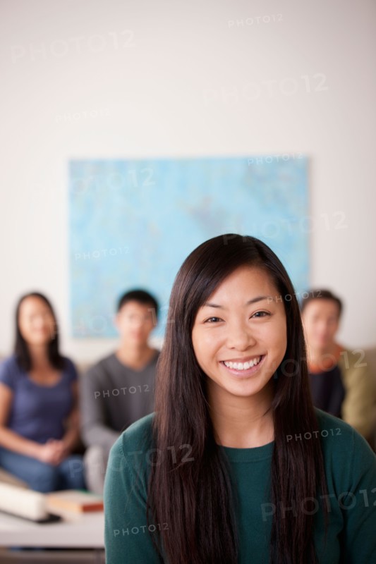 Portrait of young woman with family in background. Photo : Rob Lewine