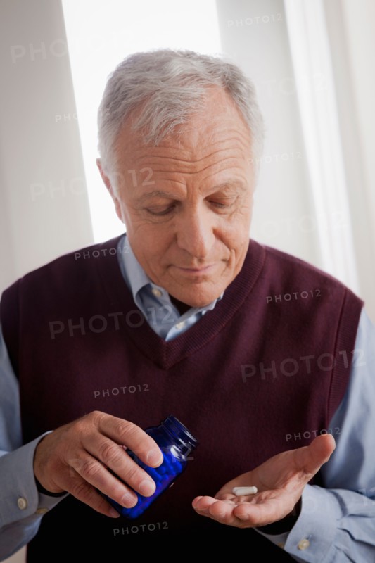 Senior man holding medicine bottle. Photo : Rob Lewine