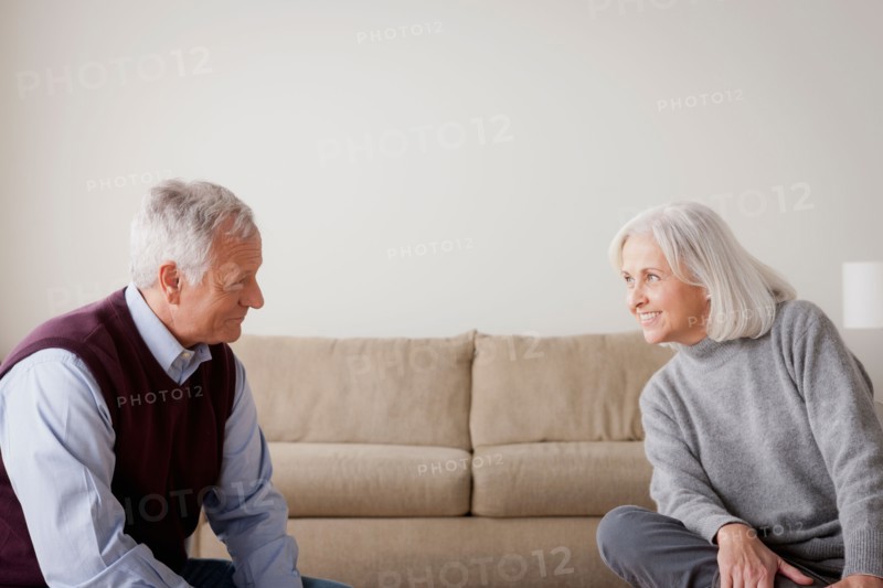 Portrait of senior couple sitting on sofa. Photo : Rob Lewine