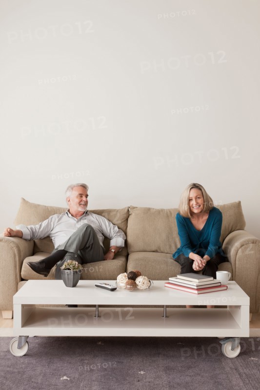 Happy senior couple sitting on sofa. Photo : Rob Lewine
