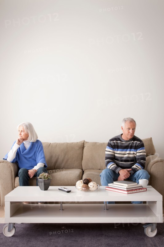 Angry senior couple sitting on sofa. Photo : Rob Lewine
