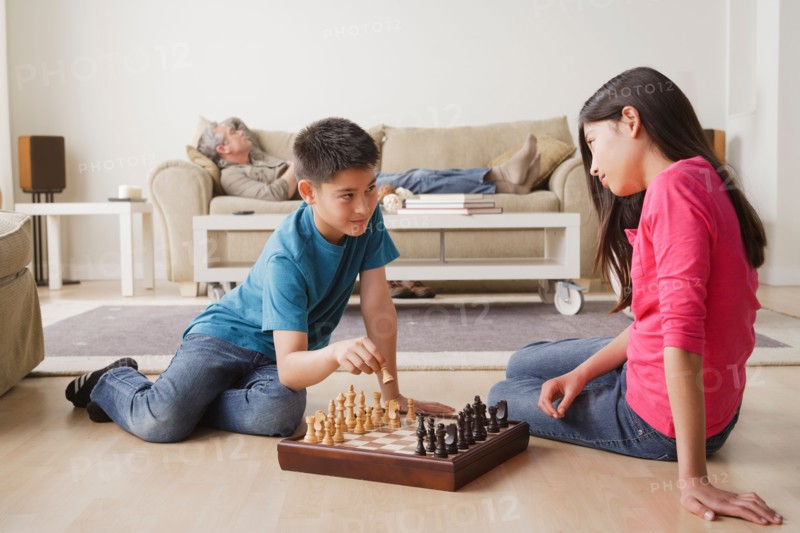 Siblings playing chess game. Photo : Rob Lewine