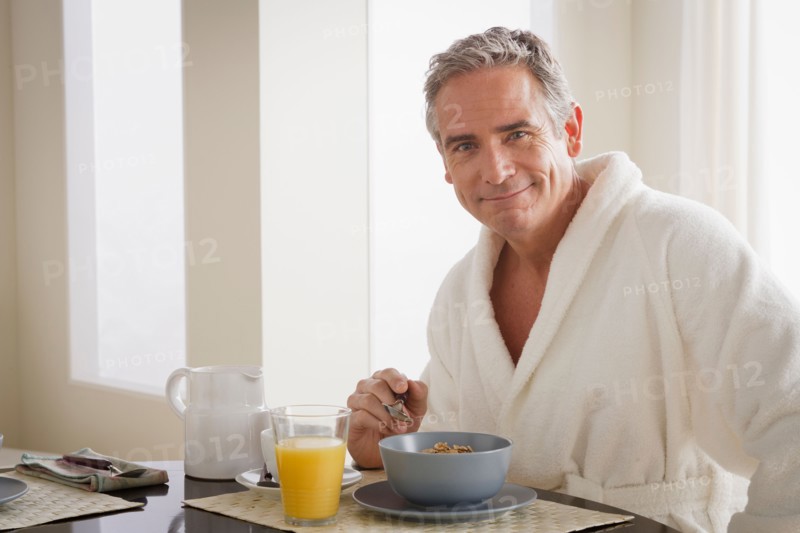 Man in bathrobe having cereal for breakfast. Photo : Rob Lewine