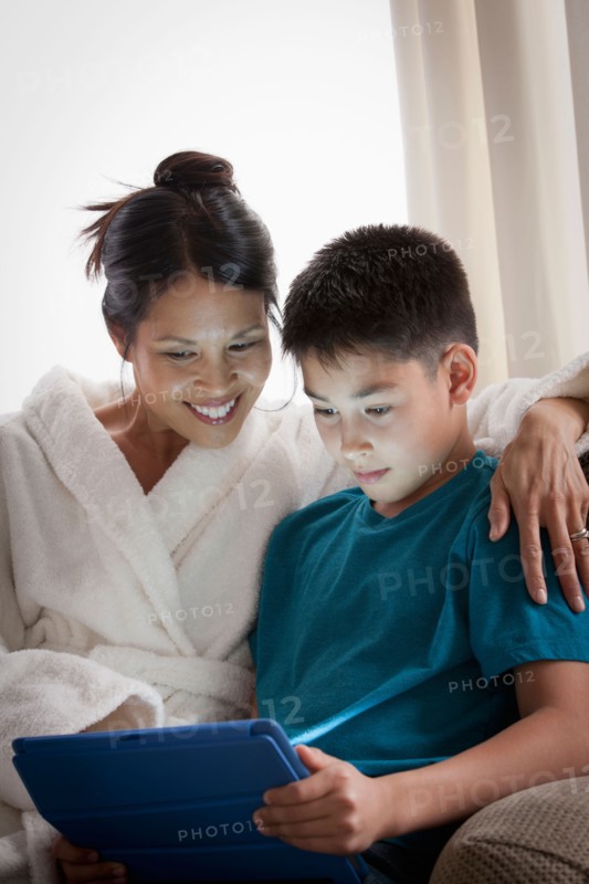 Mother embracing son using laptop. Photo : Rob Lewine