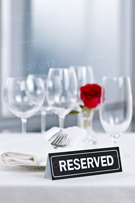 Dishes and cutlery prepared for meal in restaurant with reserved sign. Photo : Elena Elisseeva