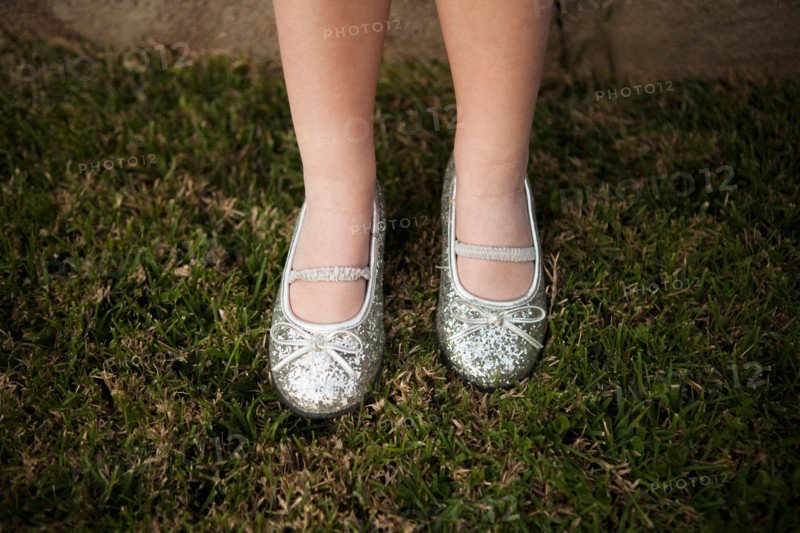 Close-up view of girl's (4-5) legs on grass. Photo : Jessica Peterson