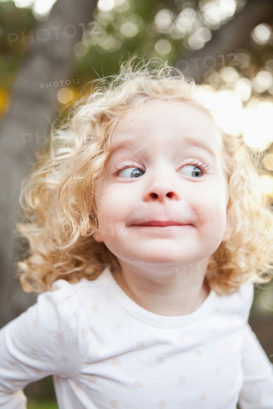Outdoor portrait of cute blonde girl (4-5) pulling funny faces. Photo : Jessica Peterson