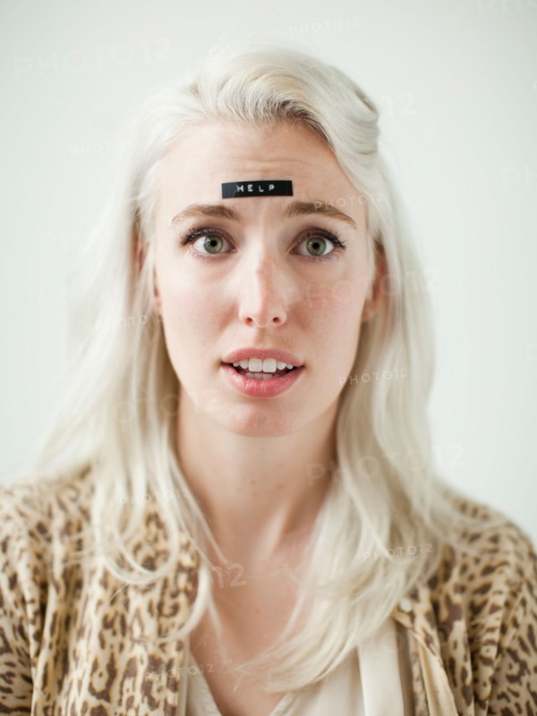 Portrait of young woman with word help on forehead. Photo : Jessica Peterson