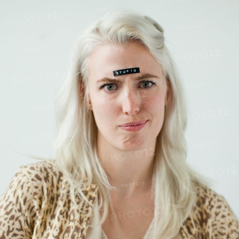 Portrait of young woman with word stupid on forehead. Photo : Jessica Peterson