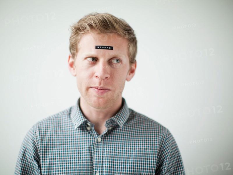 Studio shot of young man with black concept label on forehead. Photo : Jessica Peterson